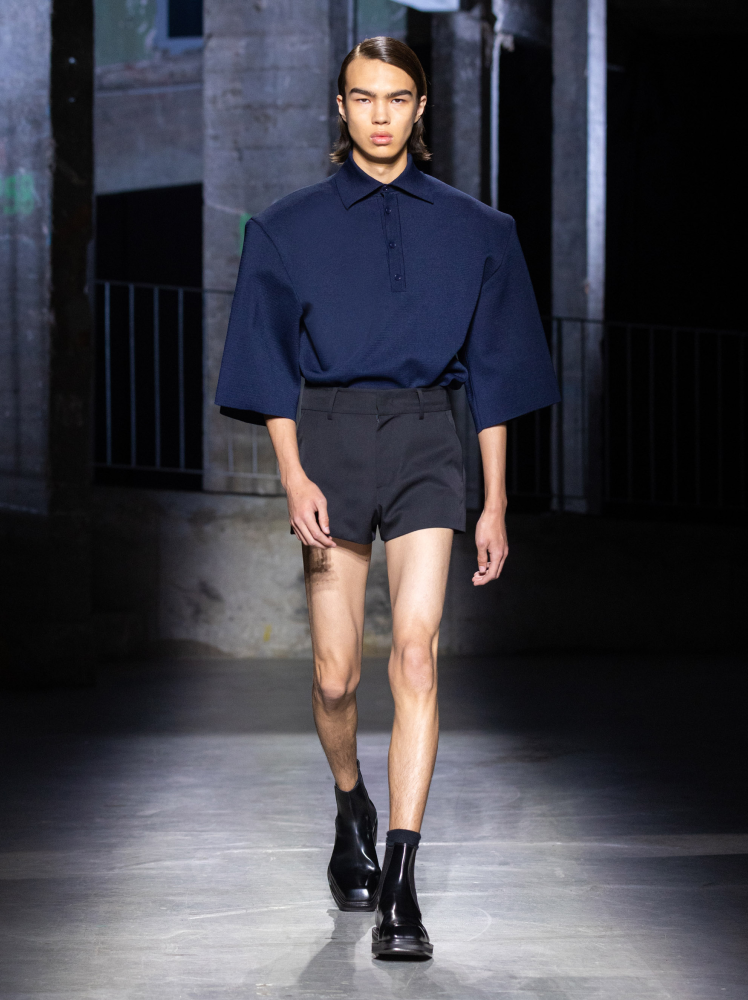 Model walks the runway in boxy Juun.J navy shirt and short tailored high-waisted shorts at Paris Fashion Week