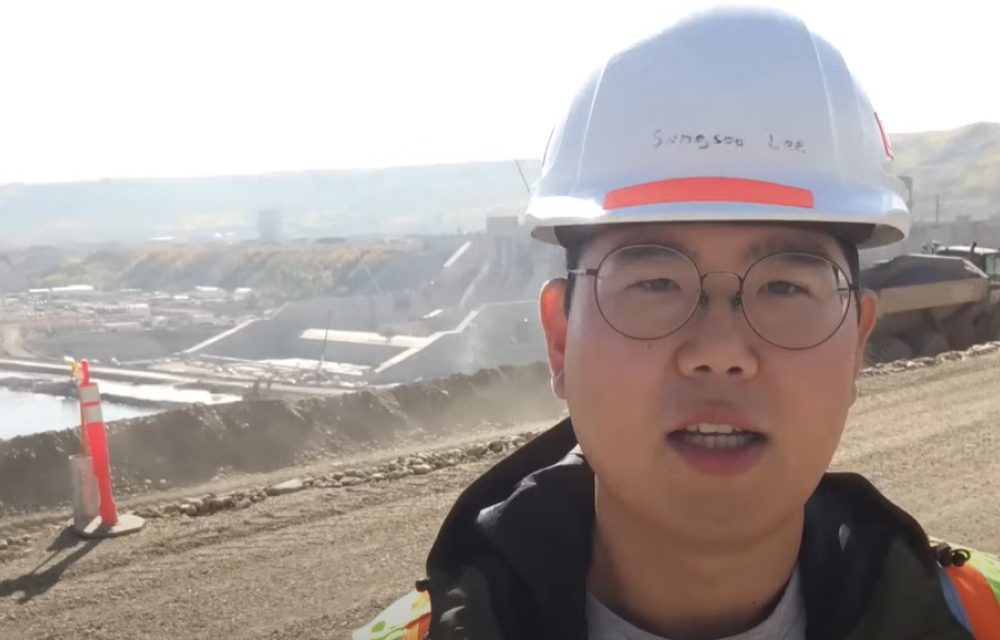 A field engineer standing in front of a construction site in Canada with a helmet on working for Samsung C&T Engineering and Construction Group