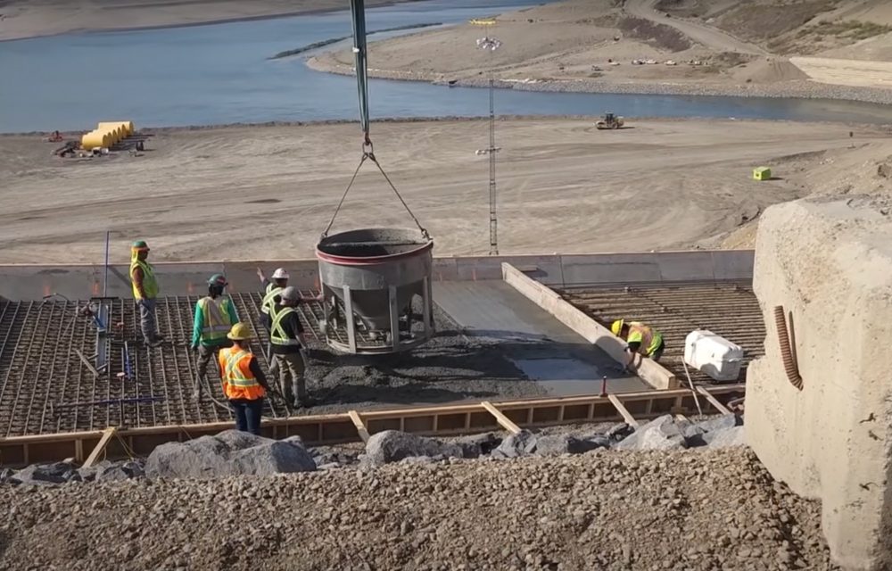 Workers installing a debris trap along a river