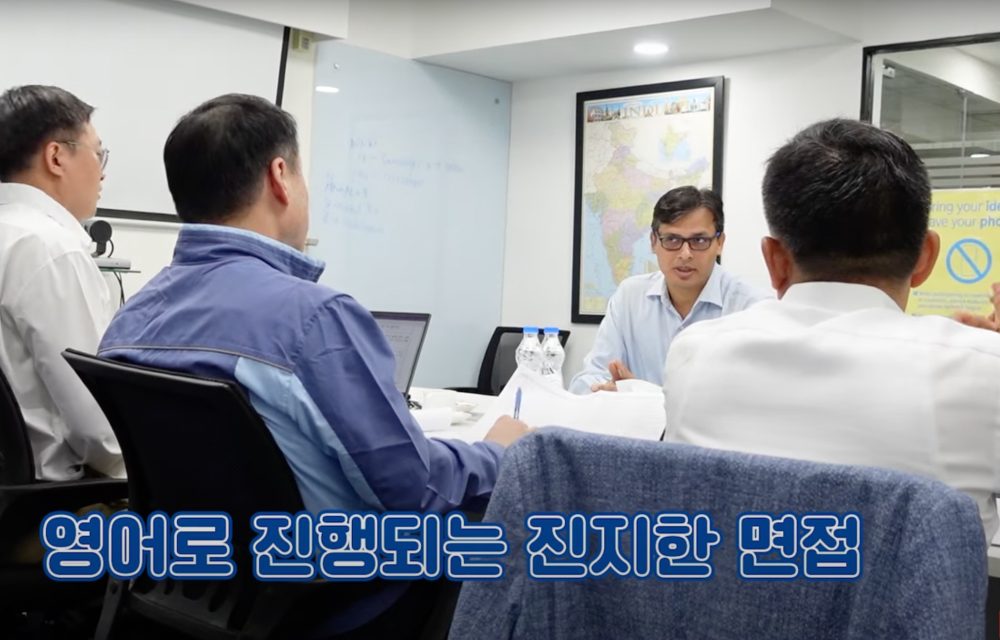 Four employees have a discussion in a meeting room at work