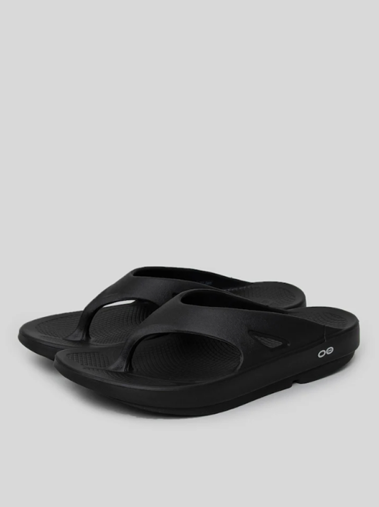 Simple black flip flops with an ergonomic design by OOFOs