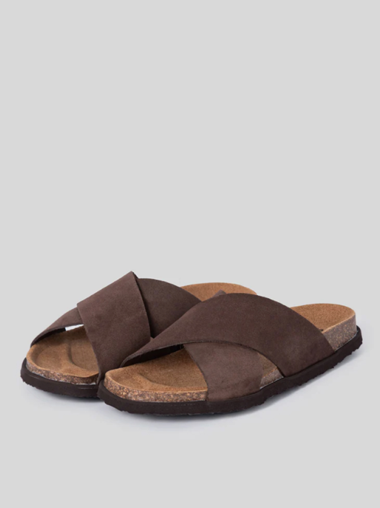 A pair of simple brown summer slide-on shoes for men with brown suede straps that cross over and a cork sole for comfort