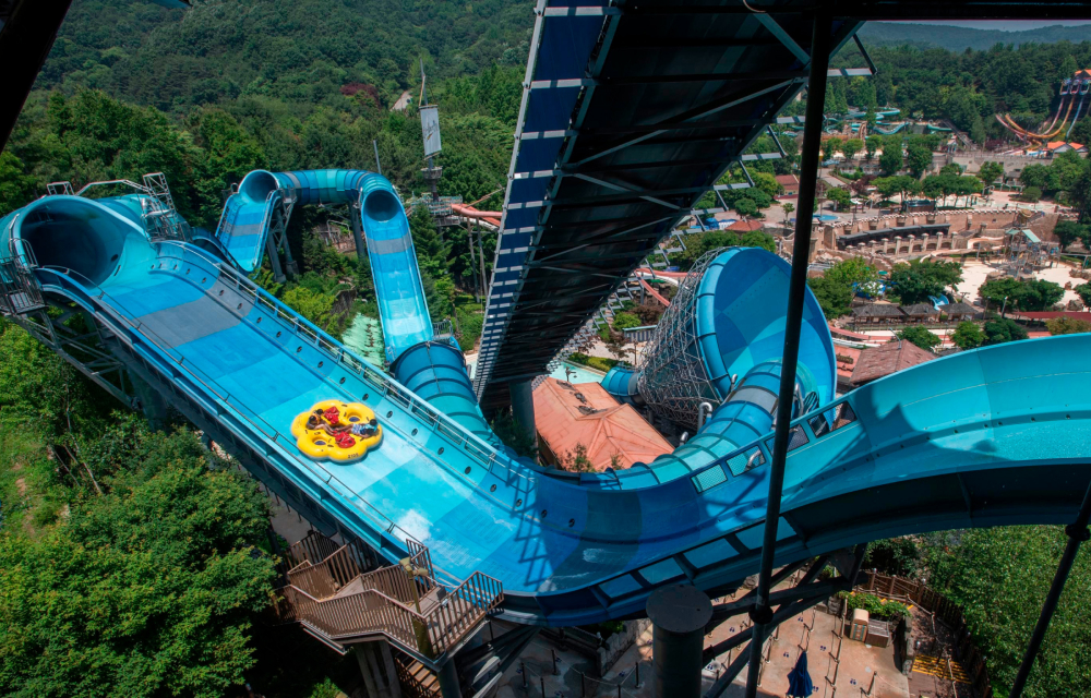 A wide image capturing the scale of Caribbean Bay’s Mega Storm water slide that features a 37-meter tower and an 18-meter-wide tornado funnel that guests can ride in a circle tube.