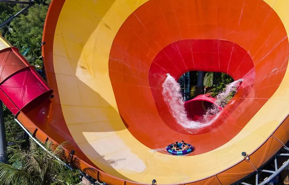 People enjoy the giant ’Vuvuzela’ tube slide at Malaysia‘s Sunway Lagoon water park that has vivid yellow and orange stripes!