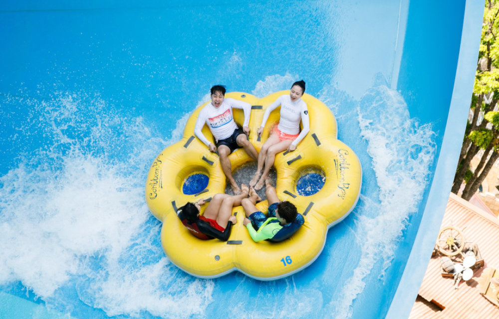 4 water park thrill seekers enjoy a tube slide in Caribbean Bay's mega storm