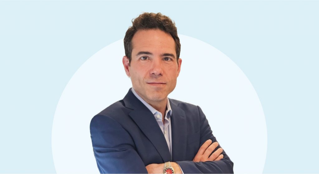 A Samsung C&T trader in a suit stands with his arms folded, looking straight at the camera against a blue background.