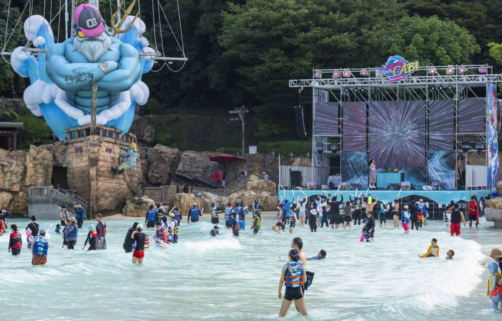 Water park goers enjoy the outdoor wave pool at Korea’s Caribbean Bay while enjoying music from a stage next to the pool.