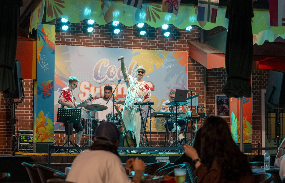 A group of musicians perform on stage at a restaurant with guests in the audience enjoying their meals.