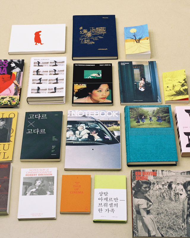 A selection of colorfully designed books in Korean and English are spread out on a flat surface organized neatly.