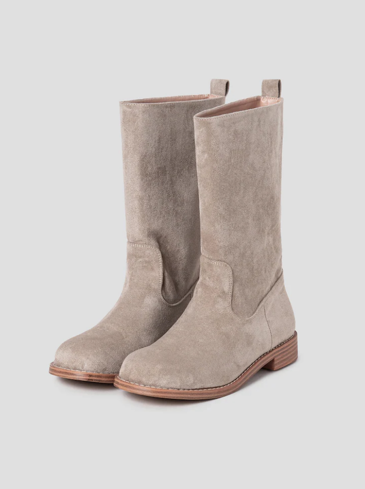 A pair of beige suede-look boots that are mid-calf height with a wooden sole detail and pull loops on the top back section of the boots.