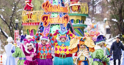 Vibrant performers in clown costumes march in a Christmas-themed parade at Korea's Everland Resort