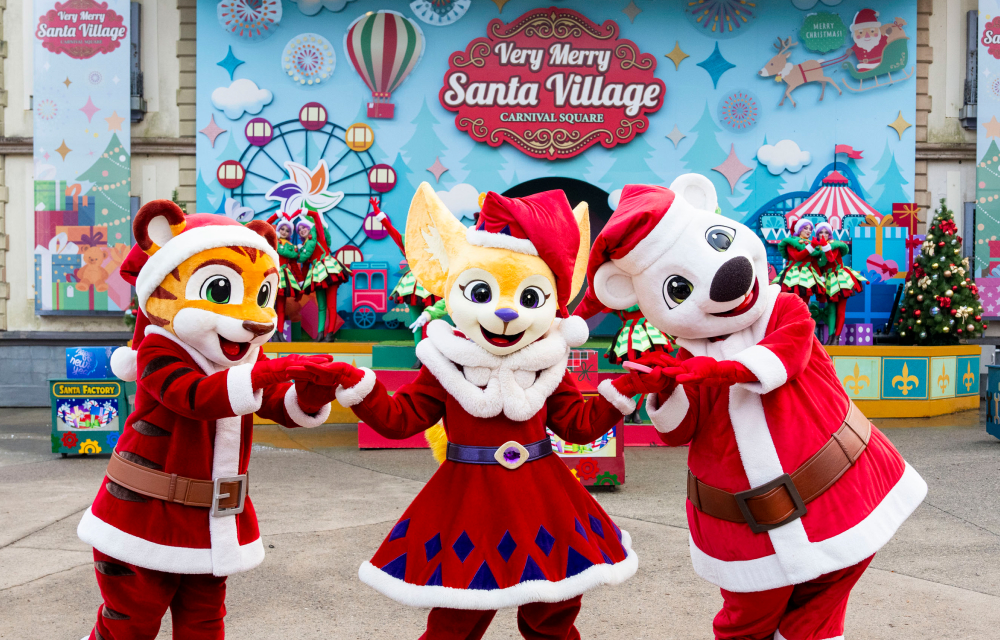 Festive mascots in Santa costumes – Cute animal mascots in Santa outfits hold hands in a cheerful Christmas setting.