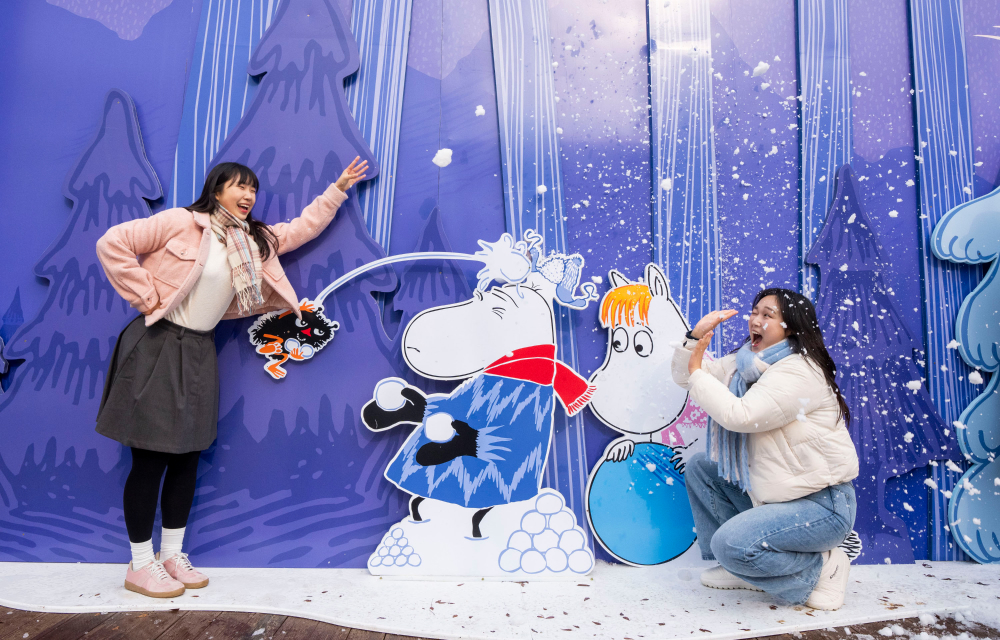 Two friends pose for a photo with Moomin and Snorkmaiden during a snowball fight at Everland!