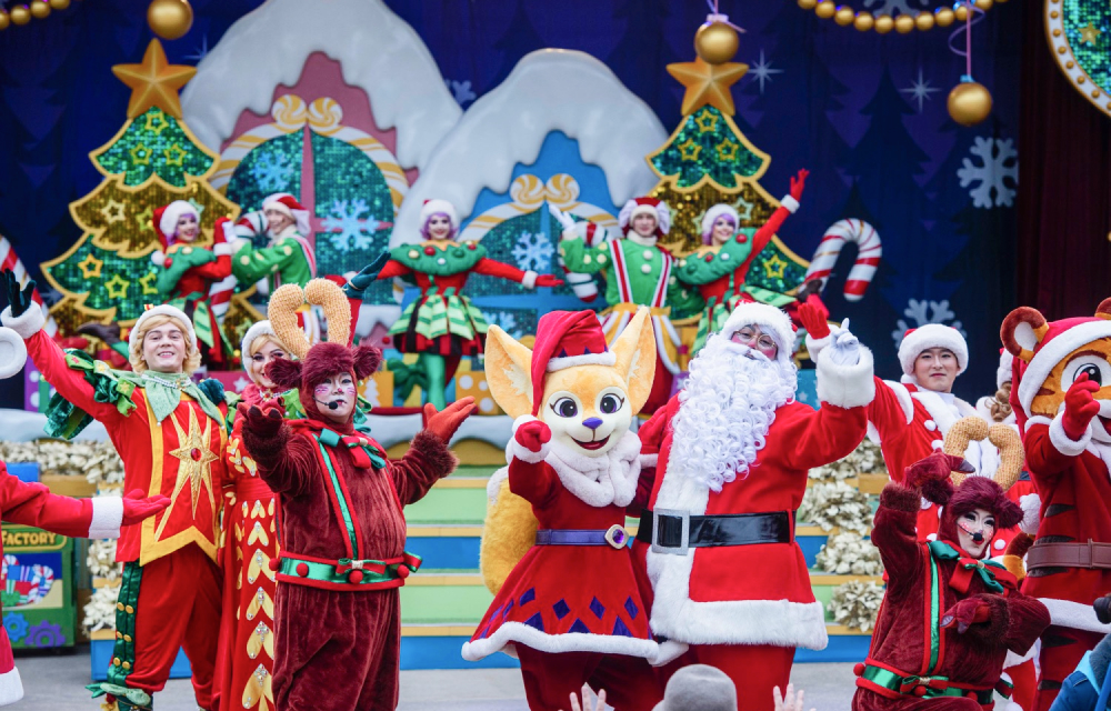 Santa and performers on stage – Santa and festive characters celebrate in a lively Christmas-themed performance.