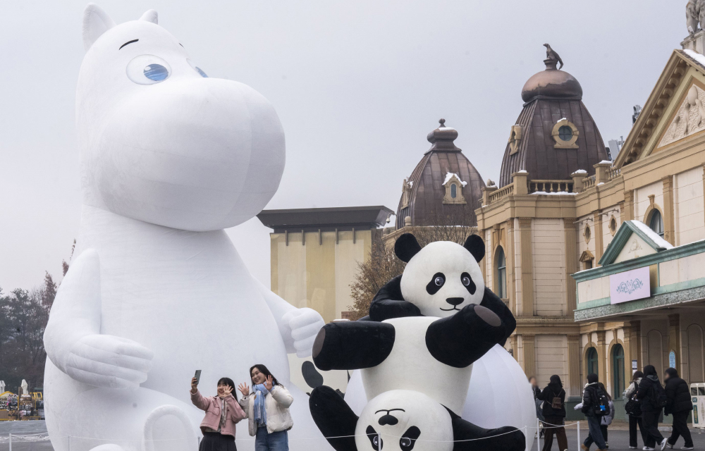 Moomin and panda statues – Large Moomin and panda figures with visitors taking photos in a winter-themed setting.