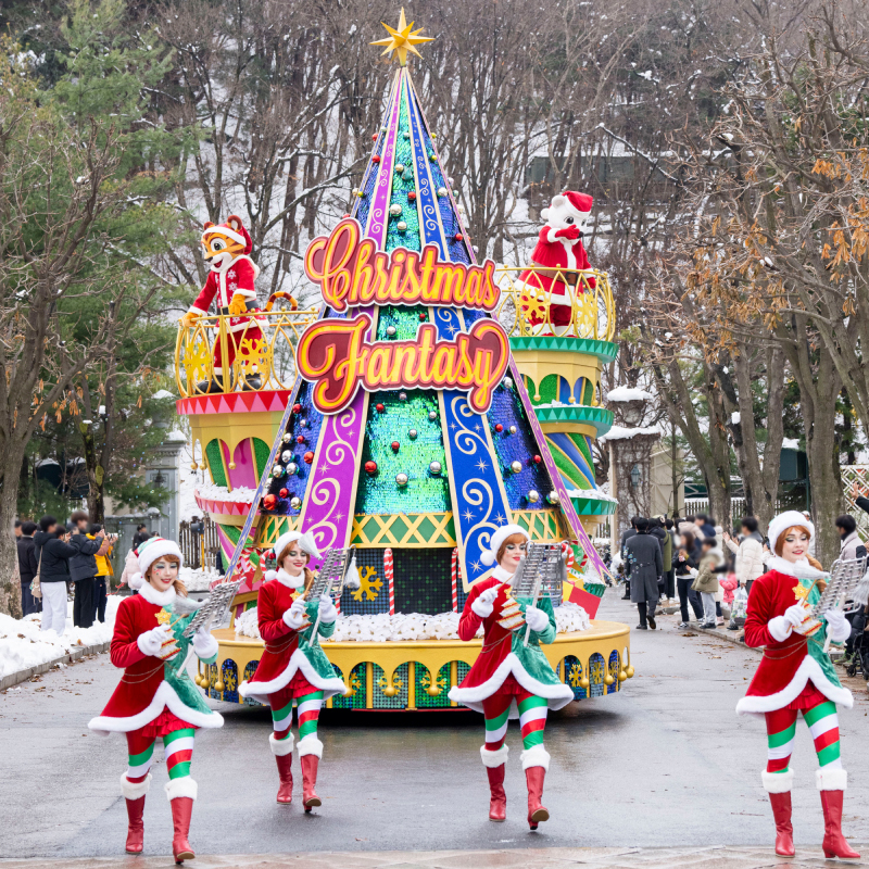 Christmas tree float and festive dancers – A decorated Christmas tree float accompanied by performers in red and green costumes.