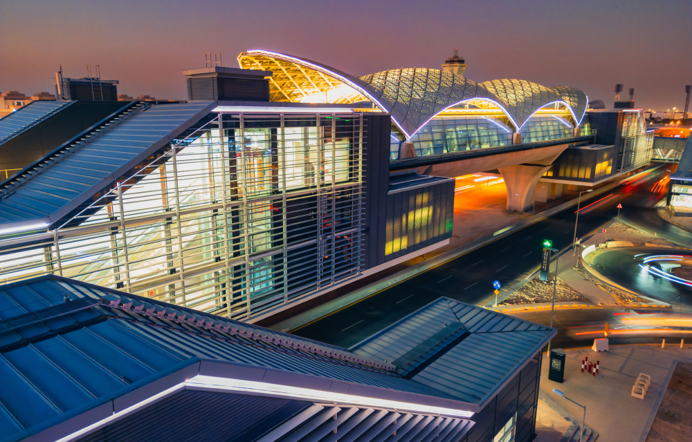 A modern Riyadh Metro station with sleek, futuristic architecture, incorporating solar-panel-covered roofs and open spaces.