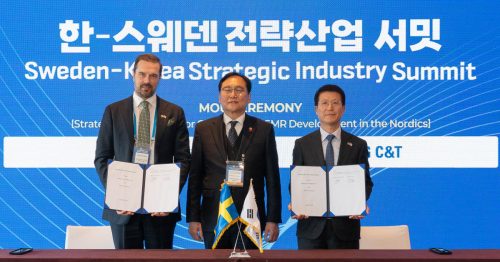 Samsung C&T and Kärnfull Next AB representatives holding signed documents at the Sweden-Korea Strategic Industry Summit, with flags of Sweden and Korea displayed on the table and event signage in the background.