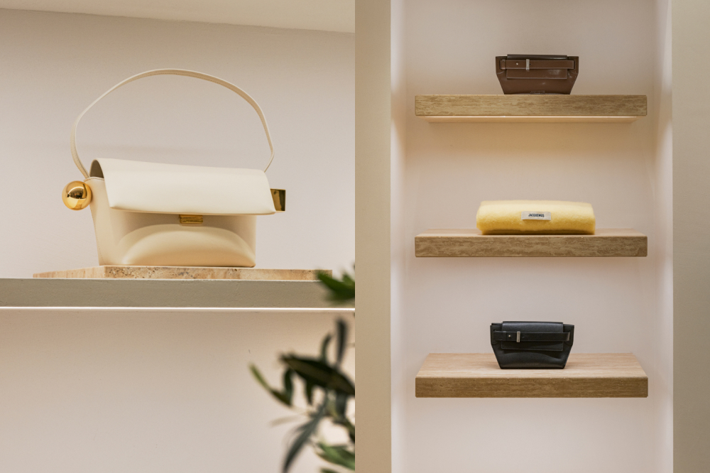 Left image: A cream Jacquemus handbag sits on a wooden shelf in a retail store. Right image: three wooden shelves in a retail store display handbags and a scarf on each shelf