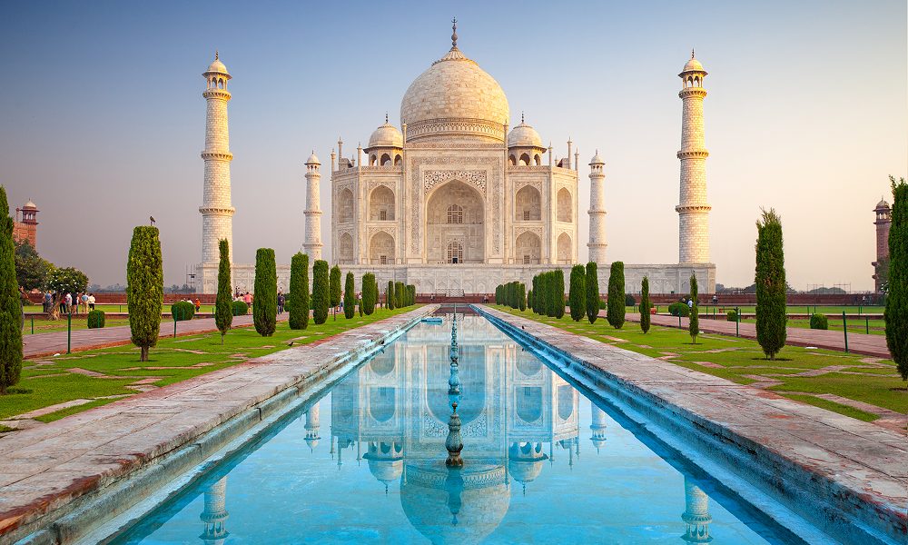 The Taj Mahal, a marble mausoleum in India, mirrored in the surrounding water, representing both love and groundbreaking architectural techniques.