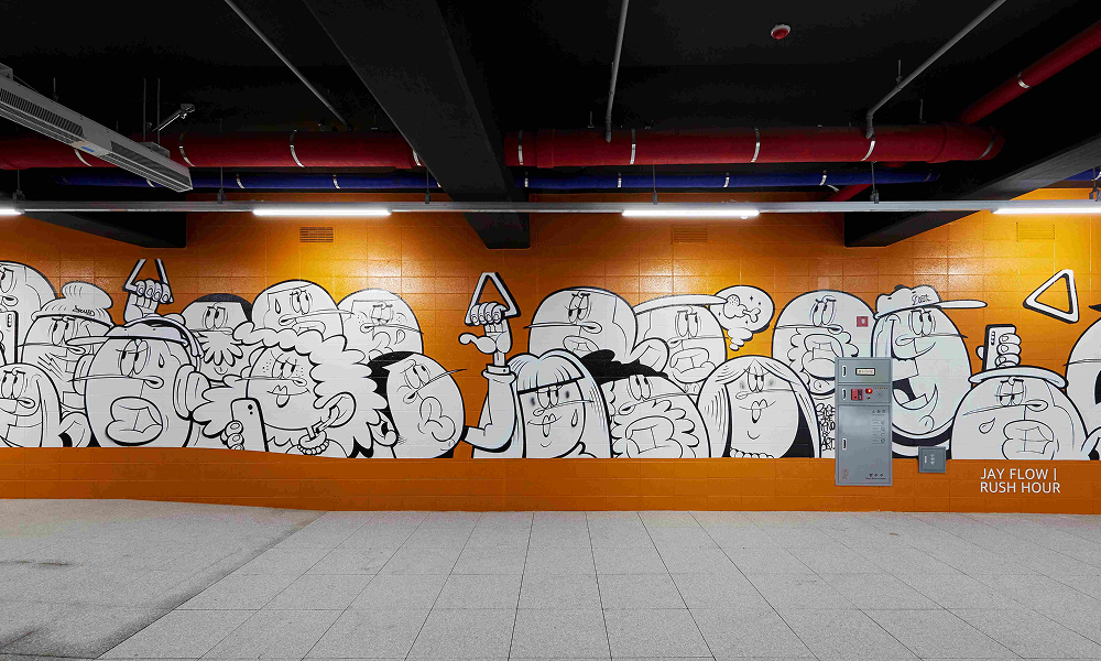 A black-and-white mural at the Raemian One Bailey Street Art Gallery, illustrating 6:00 PM in Seoul. The artwork portrays city life with expressive characters against a bold orange background, capturing the evening atmosphere in an urban setting.