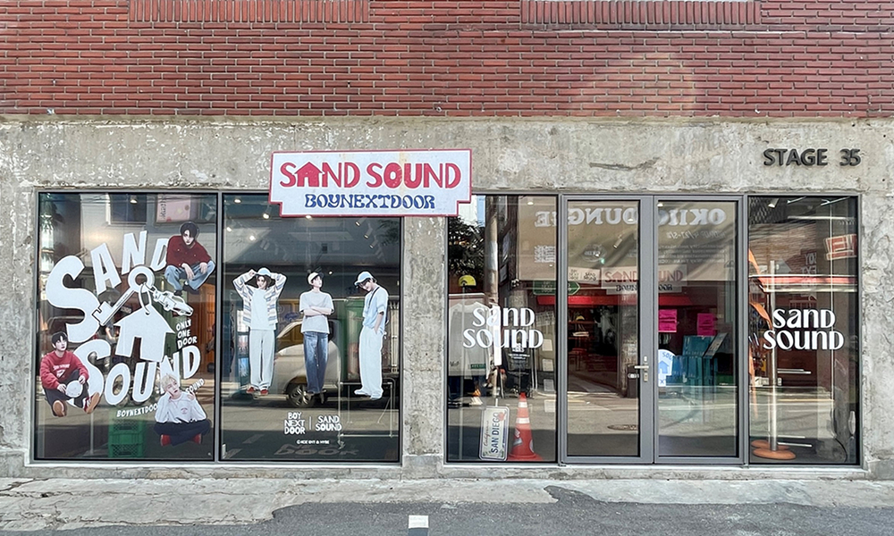 Exterior of Samsung C&T Fashion Group's 'Sand Sound' pop-up store at Stage 35 in Seongsu, featuring large glass windows with merchandise displays and a brick facade.