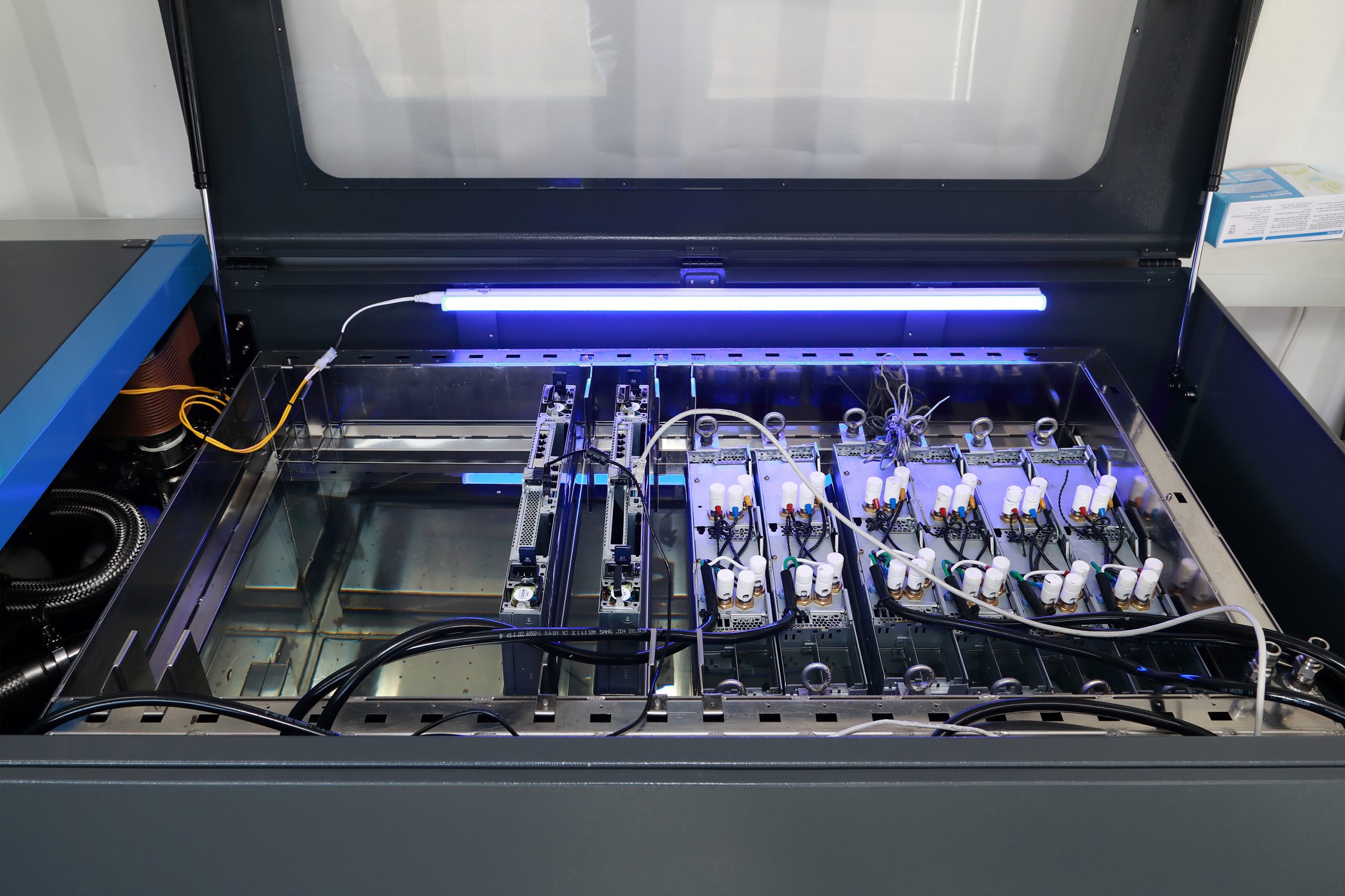 Top-down view of an immersion tank filled with dielectric coolant and submerged server racks.