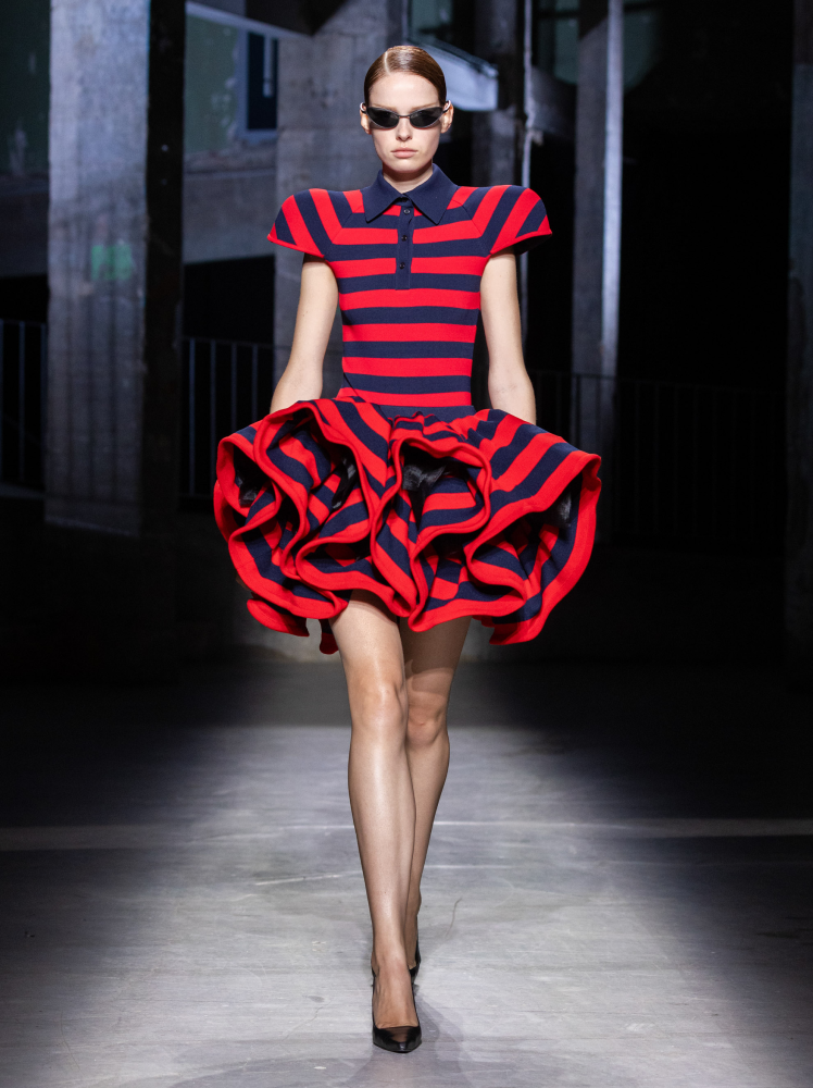 Model walks runway in Juun.J red and navy striped polo dress with flounced haute couture skirt detailing