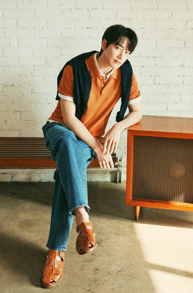 Lee Jun-hyuk wears the Cotton Silk Collar Neck Knit in yellowish brown from Beanpole’s SolSol Knit collection. Styled with blue denim and a navy sweater casually draped over his shoulders, the look combines soft textures with a calm, earthy palette.