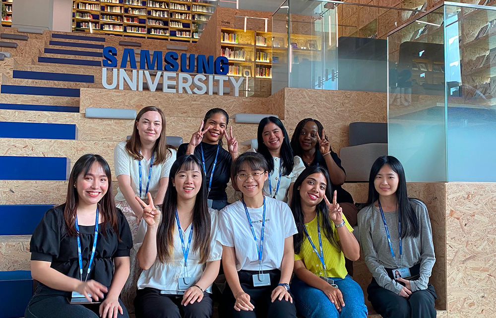 Trainees sitting on the stairs at Samsung University during a group training and networking session.