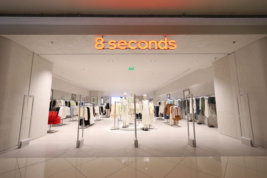 Interior view of the 8 Seconds store at SM Mall of Asia, showcasing neatly arranged clothing racks, mannequins in neutral-toned outfits, and a spacious, modern retail layout.