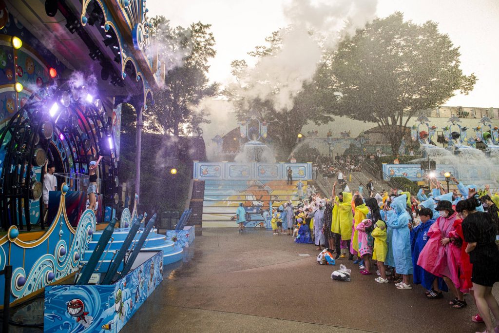 A DJ and host energize the crowd during Everland’s Bam Bam Summer Night, with smoke and water effects filling the air.