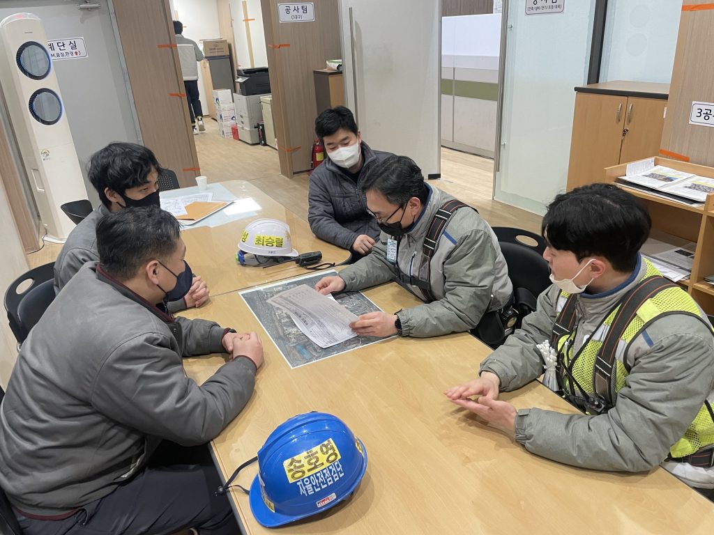 Safety team members hold a worksite meeting to review plans and coordinate tasks