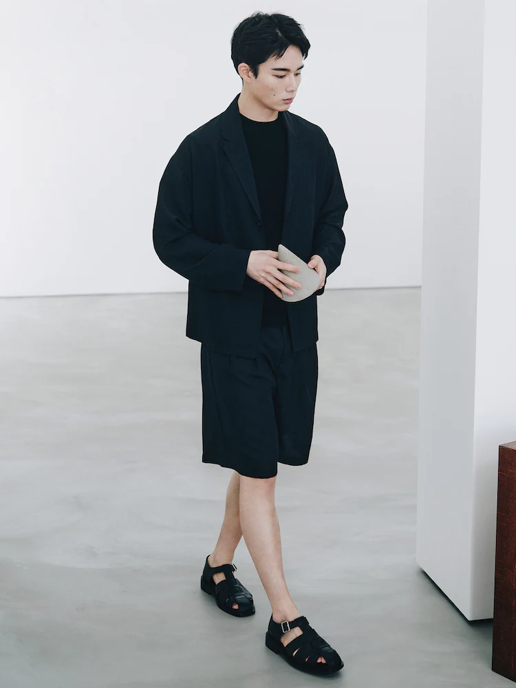 Model wears ShiftG black Wide Fit Shorts styled with a matching blazer and black top. The look delivers lightweight comfort and refined coordination for city-ready outfits.