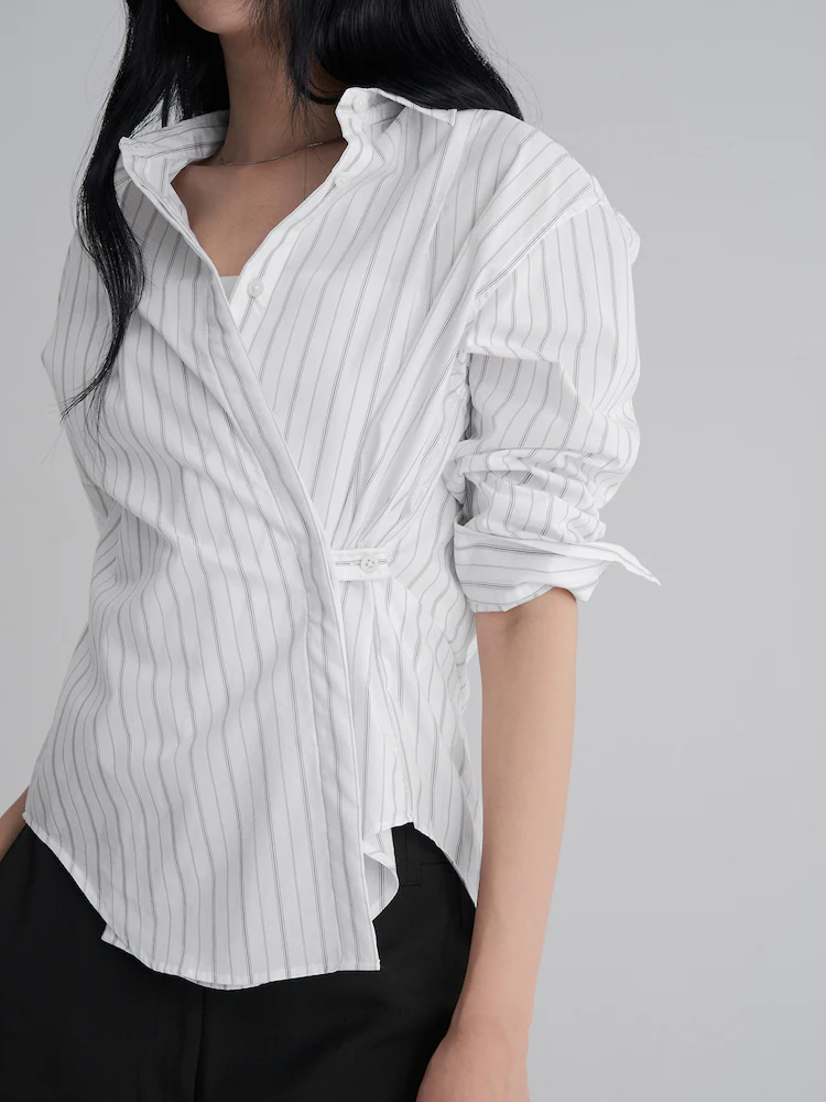 Model wearing the 8seconds Mono Stripe Cinched Shirt in White, styled with relaxed black trousers. The shirt features vertical stripes, a cinched side closure, and a lightweight cotton–nylon blend for transitional wear.