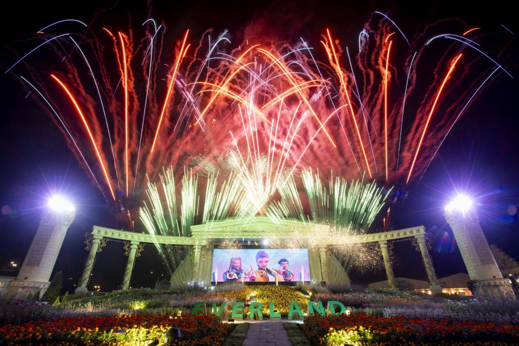 Colorful fireworks explode above the Everland stage featuring K-Pop Demon Hunters visuals on a large screen.