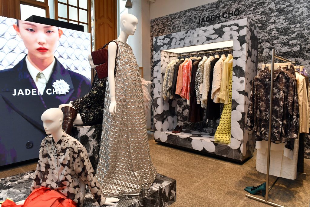 Wide view of the JADEN CHO exhibition at BEAKER Cheongdam, with mannequins dressed in floral prints, textured dresses, and boots, surrounded by patterned walls and curated garment racks.