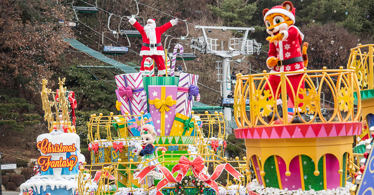 Santa and costumed characters perform atop brightly decorated Christmas floats during Everland’s Bling Bling X-mas Parade, surrounded by winter-themed decorations and falling snow effects.