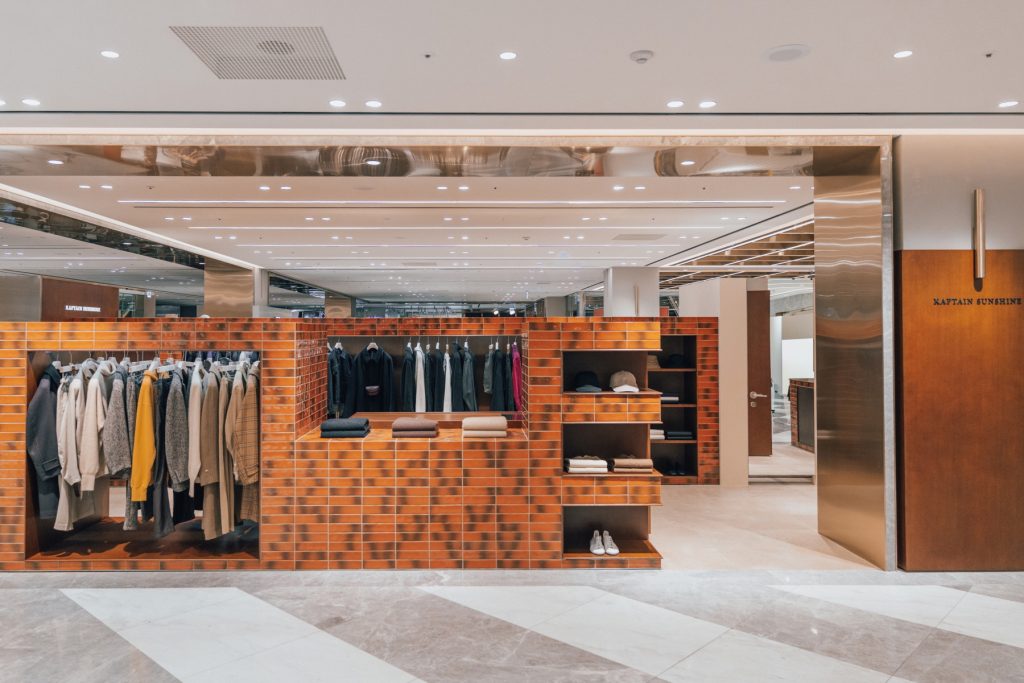 Inside the Captain Sunshine store at Shinsegae Department Store Gangnam, featuring a minimalist retail layout.
