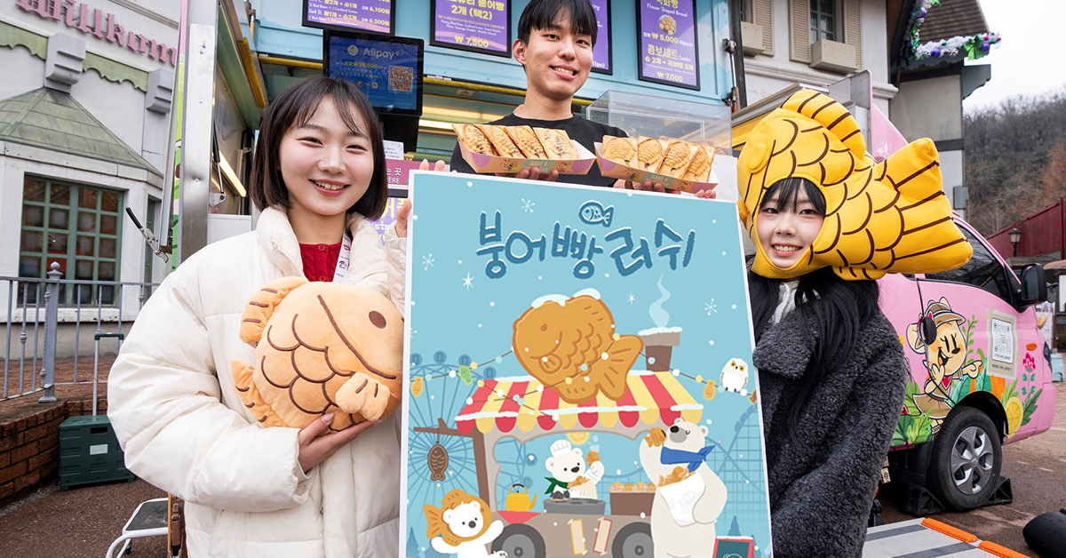 Three models holding an illustrated “Bungeoppang Rush” poster in front of a winter-themed food truck selling fish-shaped pastries at Everland