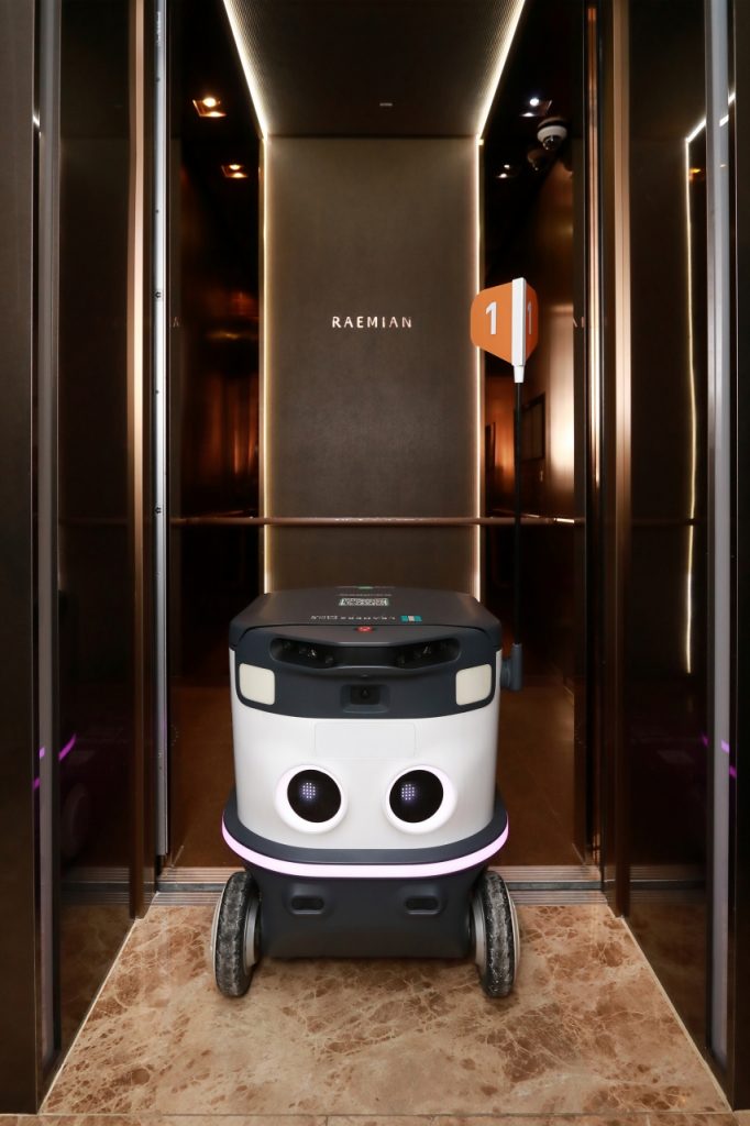 Food delivery robot operating inside an apartment elevator as part of a door-to-door delivery service.