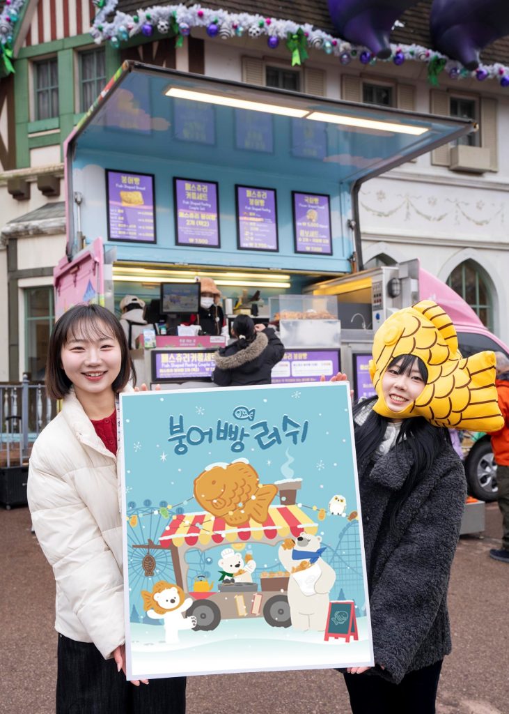 Three people standing in front of a bungeoppang stand at Everland, holding trays of fish-shaped pastries and an illustrated “Bungeoppang Rush” event poster