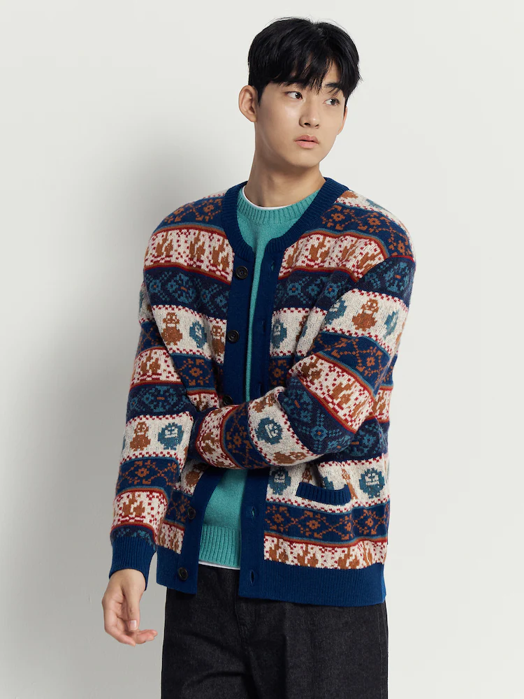 Model wearing a blue Beanpole FUZZYETI patterned cardigan with a knit top and dark trousers in a studio setting.