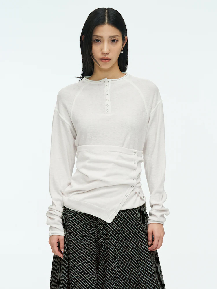 ‘anggae’ white layering tube top with asymmetrical wrap-style detailing, side buttons, and a soft layered look.