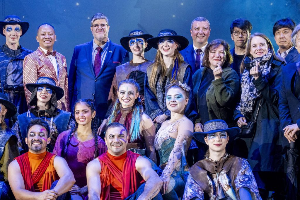 Canadian Ambassador to Korea and Québec Government representatives stand with Cirque Éloize performers in costume on stage after the Wings of Memory circus performance at Everland