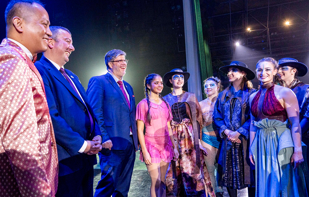 Canadian Ambassador to Korea and Québec Government representatives stand on stage speaking with Cirque Éloize performers in costume after the Wings of Memory circus performance at Everland