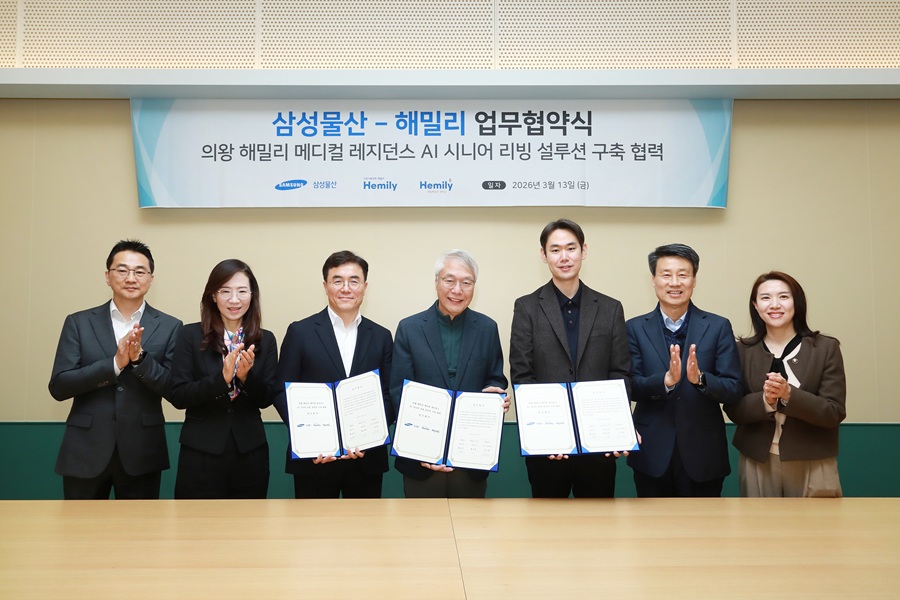 Representatives from Samsung C&T and Hemily pose together holding signed agreements during an MOU ceremony for AI-based senior living solutions.