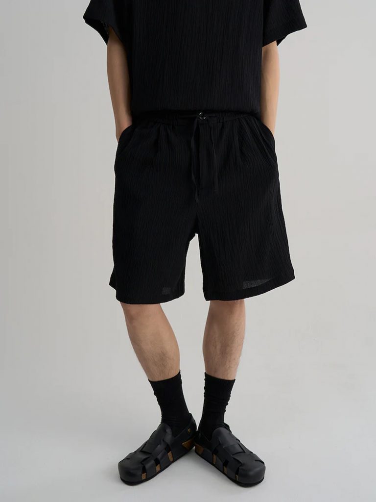 Model wearing 8seconds ALL-DAY CREASE Banding Shorts in black with a matching short-sleeve shirt and white sneakers.