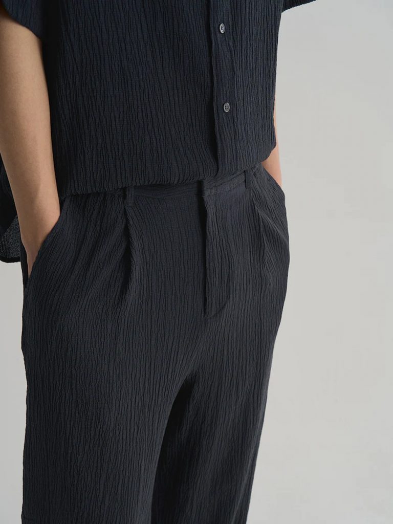 Model wearing 8seconds ALL-DAY CREASE Wide-Fit Set-Up Pants in navy with matching short-sleeve shirt.