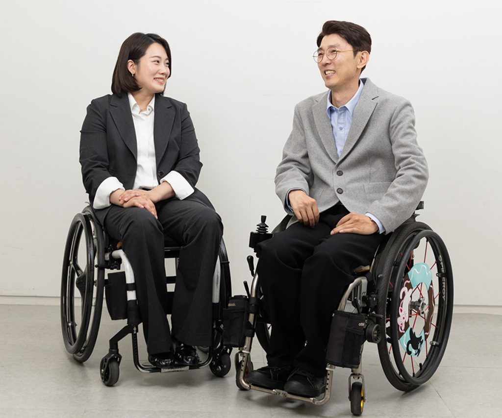 Two models in wheelchairs wearing Heartist business casual clothing from Samsung C&T Fashion Group.